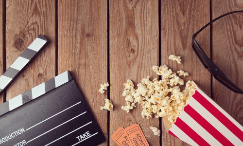 Movie clapper board, 3d glasses and popcorn on wooden background. Cinema concept.Top view from above